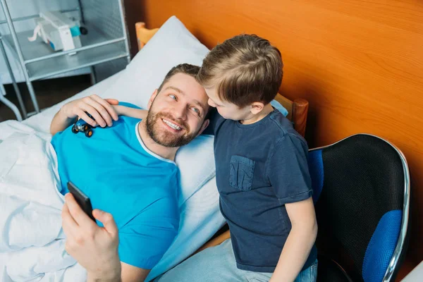 Padre con hijo abrazándose en la sala - foto de stock