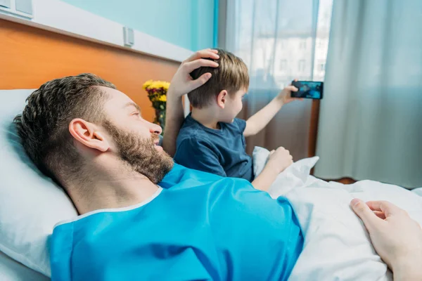 Pai e filho tomando selfie na enfermaria — Fotografia de Stock