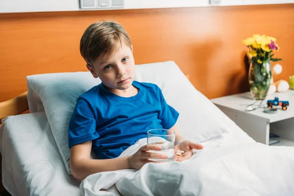 Boy with glass of water and medicines — Stock Photo