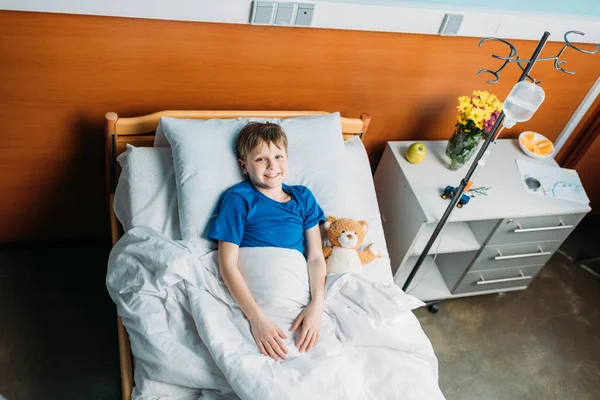 Petit garçon dans le lit d'hôpital — Photo de stock