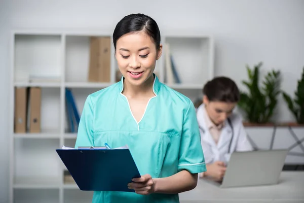 Internist holding clipboard with diagnosis — Stock Photo