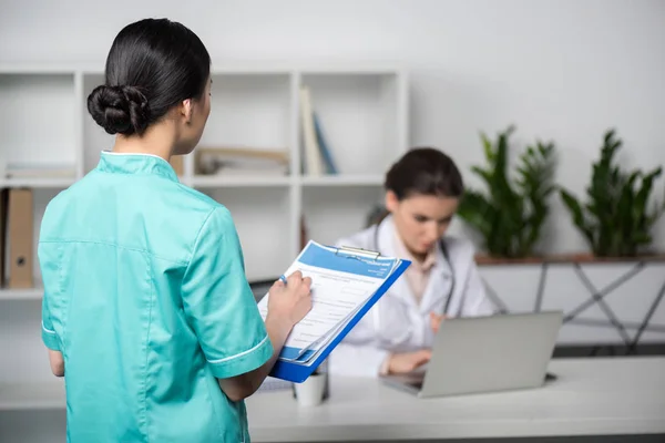 Internist holding clipboard with diagnosis — Stock Photo
