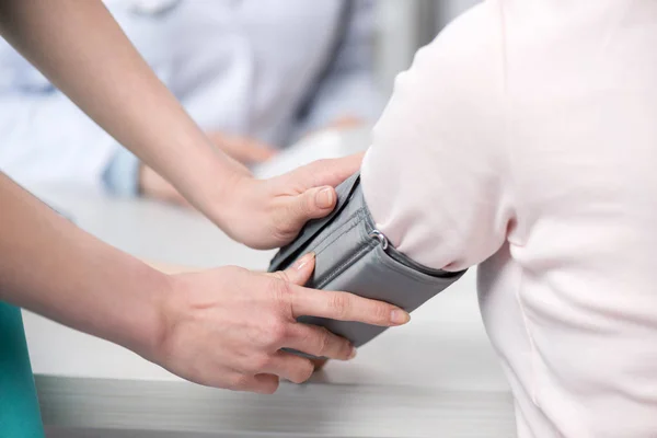 Médico midiendo la presión arterial al paciente - foto de stock