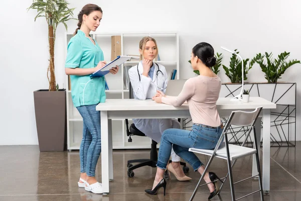 Personal médico y paciente joven - foto de stock