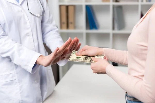 Paciente dando dinero al médico - foto de stock