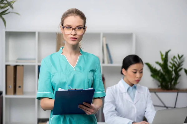 Young doctor with clipboard — Stock Photo