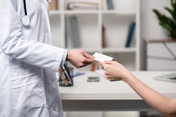 Médico dando tarjeta al paciente - foto de stock