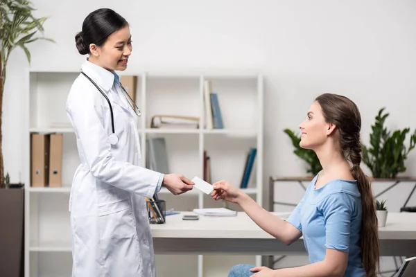 Doctor giving card to patient — Stock Photo