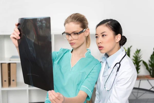 Médicos que miran la imagen de rayos X juntos - foto de stock
