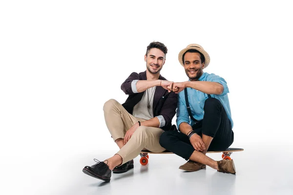 Young friends sitting on skateboard — Stock Photo