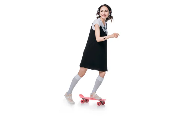 Дівчина слухає музику і їде на скейтборді — стокове фото