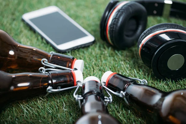 Botellas de cerveza con smartphone y auriculares - foto de stock