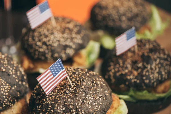 Sabrosas hamburguesas con banderas americanas - foto de stock