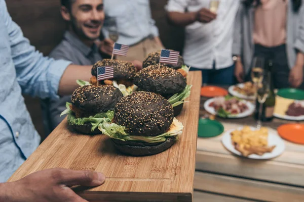 Jovens que comem hambúrgueres — Fotografia de Stock