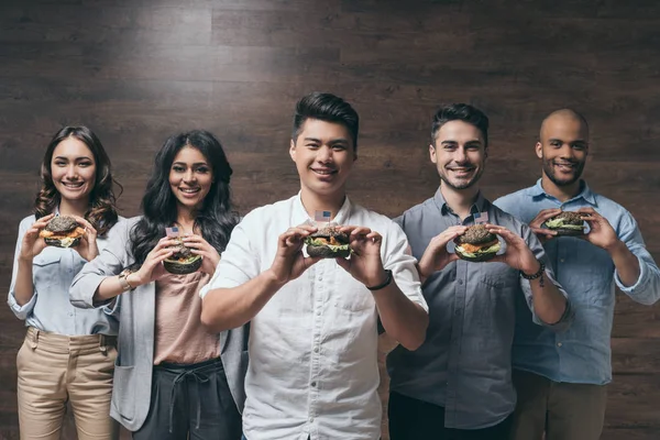 Jóvenes comiendo hamburguesas - foto de stock