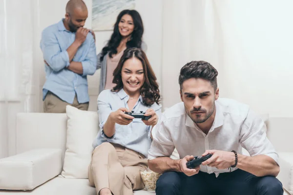 Amigos jugando videojuegos en casa - foto de stock