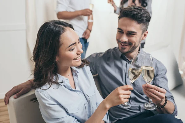 Jeune couple cliquetis avec verres à champagne — Photo de stock