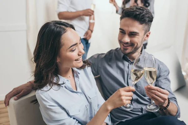 Pareja joven tintineo con copas de champán - foto de stock