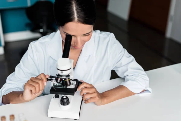 Científico con microscopio en laboratorio - foto de stock