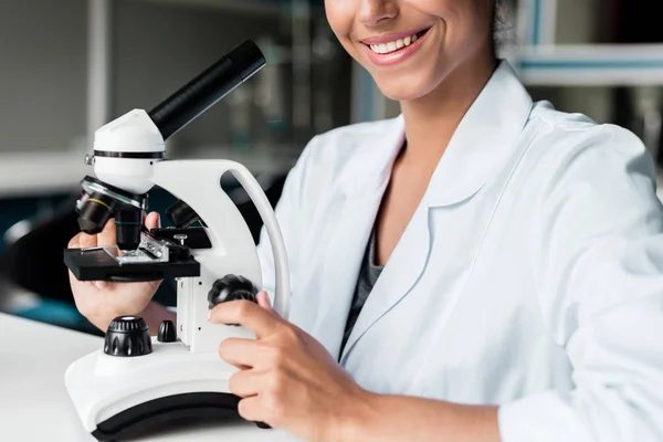 Científico con microscopio en laboratorio - foto de stock