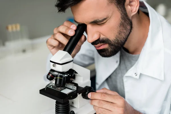 Вчений, що працює з мікроскопом — стокове фото