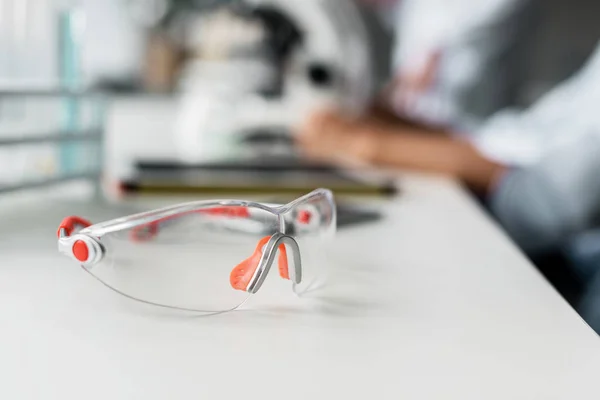 Gafas protectoras en mesa de laboratorio - foto de stock