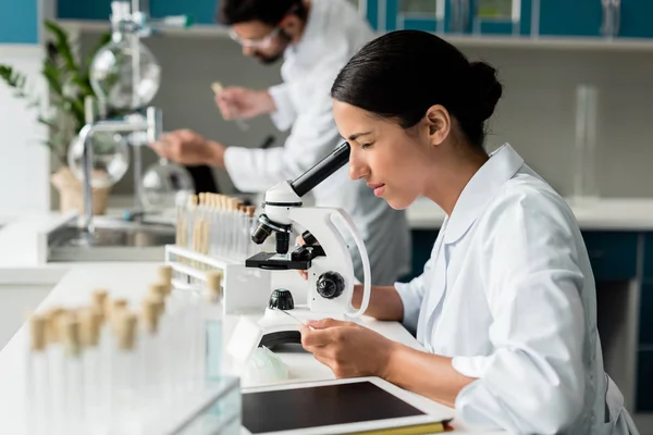 Científico trabajando con microscopio - foto de stock