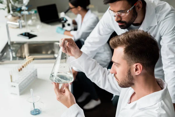 Científicos examinando frasco - foto de stock