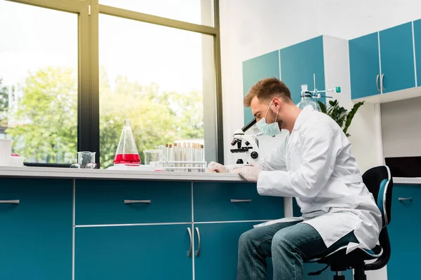 Cientista que trabalha com microscópio — Fotografia de Stock