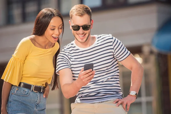 Pareja multiétnica usando smartphone - foto de stock