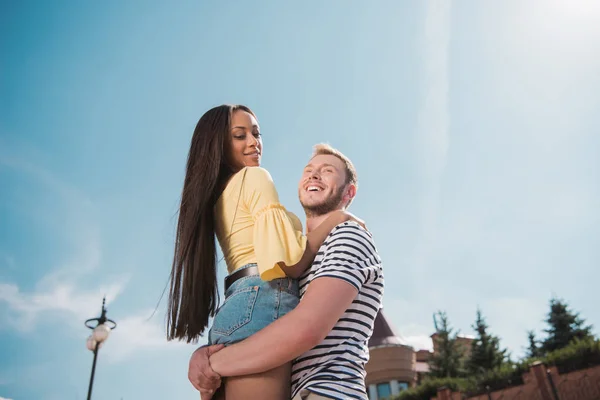 Multiethnic couple hugging in city — Stock Photo