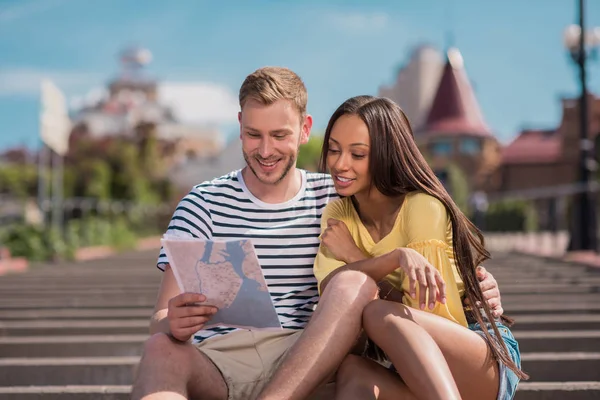 Multiethnic couple of tourists with map — Stock Photo