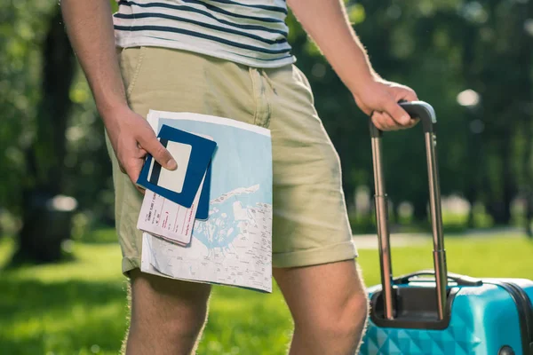 Hombre con maleta, pasaportes y mapa - foto de stock