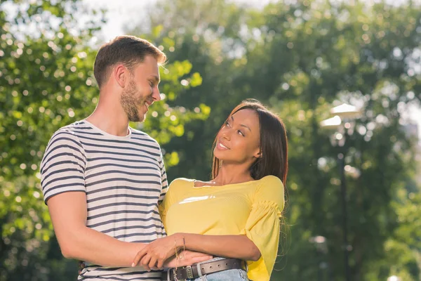 Casal multiétnico abraçando no parque — Fotografia de Stock