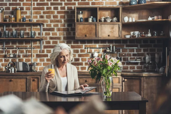 Frau schaut sich Fotoalbum an — Stockfoto