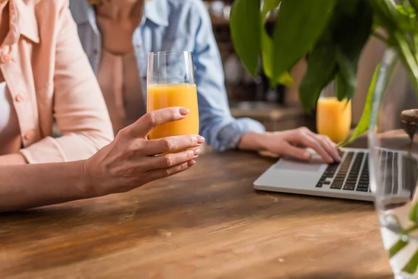 Women using laptop in kitchen — Stock Photo