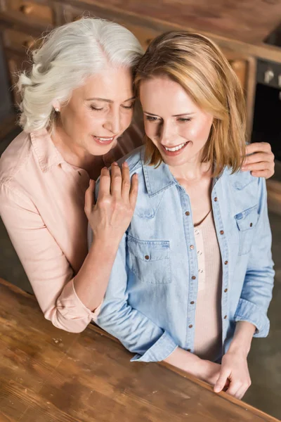 Deux femmes étreignant dans la cuisine — Photo de stock