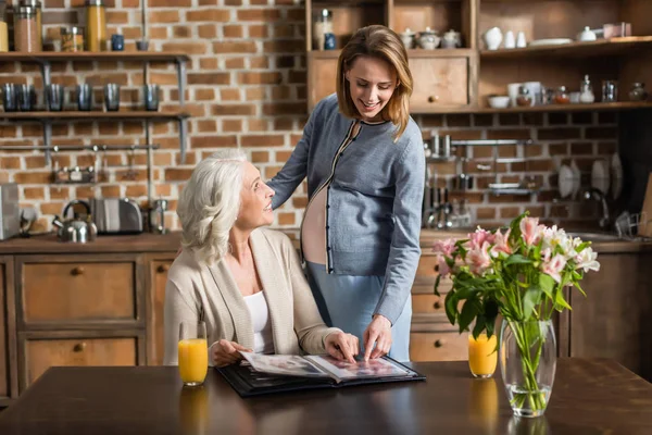 Pregnant woman and her mother on kitchen — Stock Photo