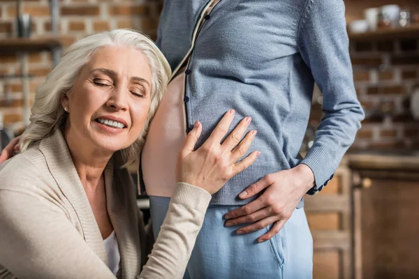 Senior woman listening belly — Stock Photo