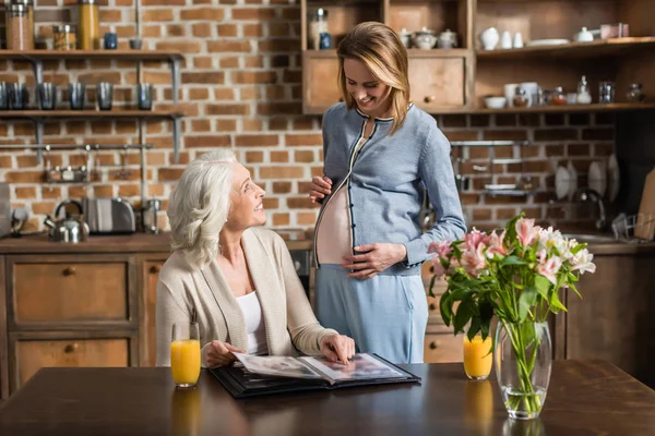 Donna incinta e sua madre in cucina — Foto stock