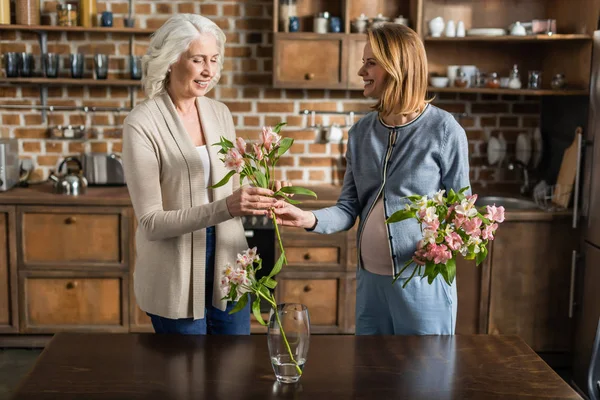 Pregnant woman and her mother on kitchen — Stock Photo