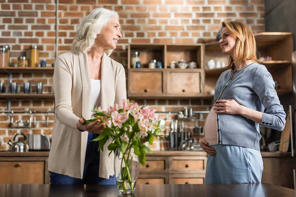 Pregnant woman and her mother on kitchen — Stock Photo