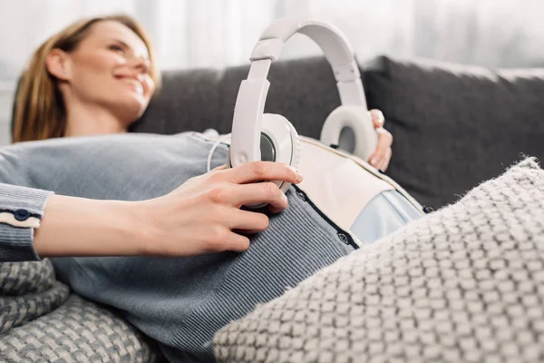 Mulher grávida com fones de ouvido na barriga — Fotografia de Stock