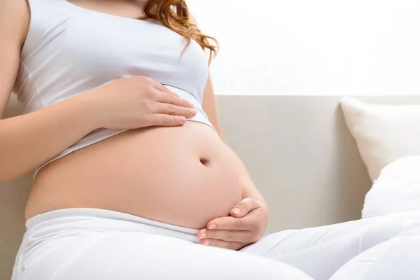Pregnant woman touching her belly — Stock Photo