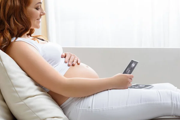 Pregnant woman with ultrasound scans — Stock Photo