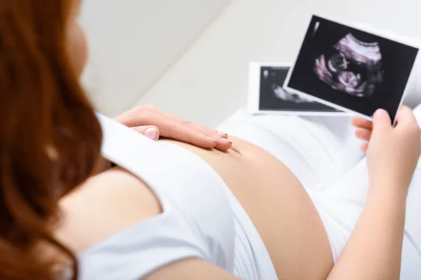 Pregnant woman with ultrasound scans — Stock Photo