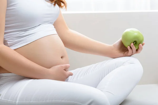 Pregnant woman holding apple — Stock Photo