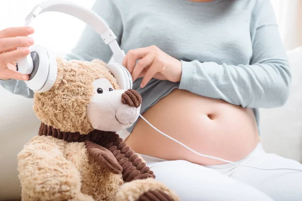 Femme enceinte avec écouteurs — Photo de stock