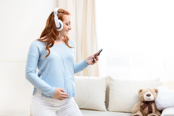 Mujer embarazada escuchando música - foto de stock