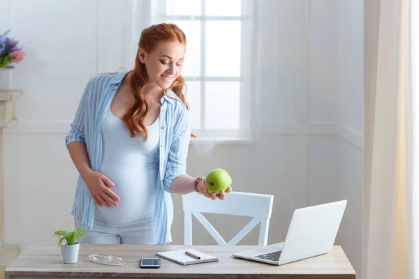 Femme enceinte tenant une pomme — Photo de stock